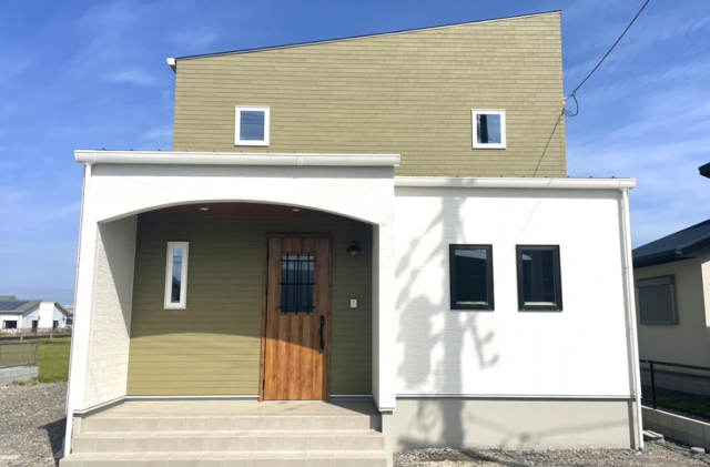 木目とグリーンの外壁に白い立体的な造形が映える片流れ屋根の2階建て - ファンライフ - 外観正面