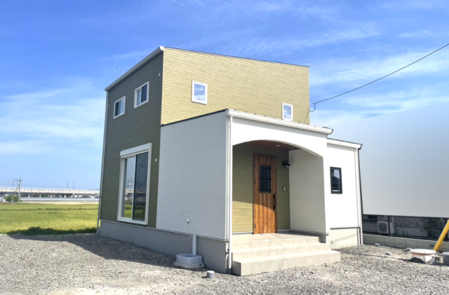 木目とグリーンの外壁に白い立体的な造形が映える片流れ屋根の2階建て - ファンライフ - 外観