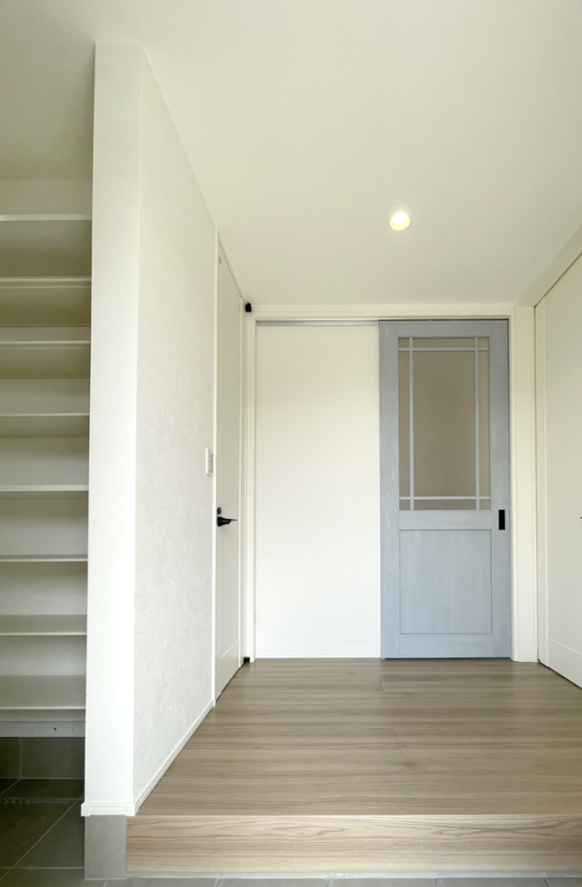 木目とグリーンの外壁に白い立体的な造形が映える片流れ屋根の2階建て - ファンライフ - 玄関