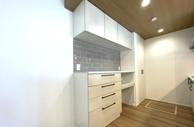 木目とグリーンの外壁に白い立体的な造形が映える片流れ屋根の2階建て - ファンライフ - キッチン収納