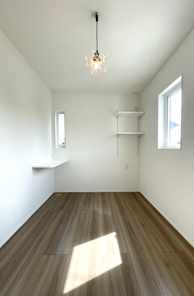 木目とグリーンの外壁に白い立体的な造形が映える片流れ屋根の2階建て - ファンライフ - 1階洋室