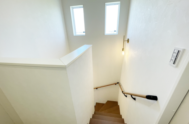 木目とグリーンの外壁に白い立体的な造形が映える片流れ屋根の2階建て - ファンライフ - 階段