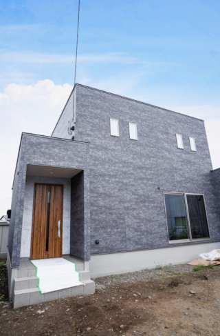 グレーのシックな外装に木目が映える重厚な玄関と開放的なLDKが響き合う2階建て - ファンライフ - 外観