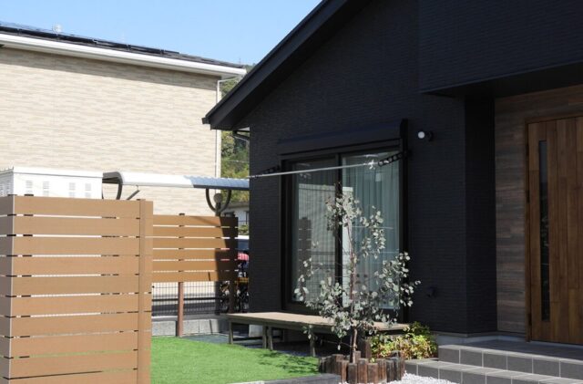 招き屋根とブラック外壁の重厚な佇まいと子育てを支える機能性が調和する平屋 - 向洋ハウジング - 庭