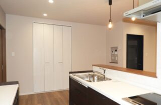 招き屋根とブラック外壁の重厚な佇まいと子育てを支える機能性が調和する平屋 - 向洋ハウジング - キッチン