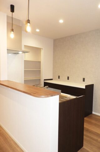 招き屋根とブラック外壁の重厚な佇まいと子育てを支える機能性が調和する平屋 - 向洋ハウジング - キッチン・パントリー