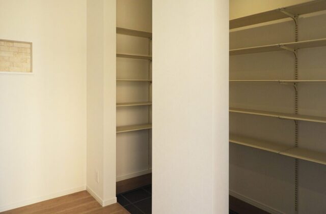 黒のガルバリウムに木のアクセントが映える豊富な収納を備えたモダンな平屋 - 向洋ハウジング - 玄関収納