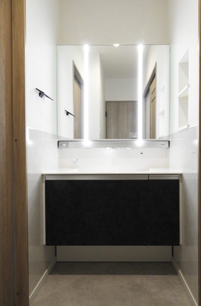 黒のガルバリウムに木のアクセントが映える豊富な収納を備えたモダンな平屋 - 向洋ハウジング - 洗面スペース