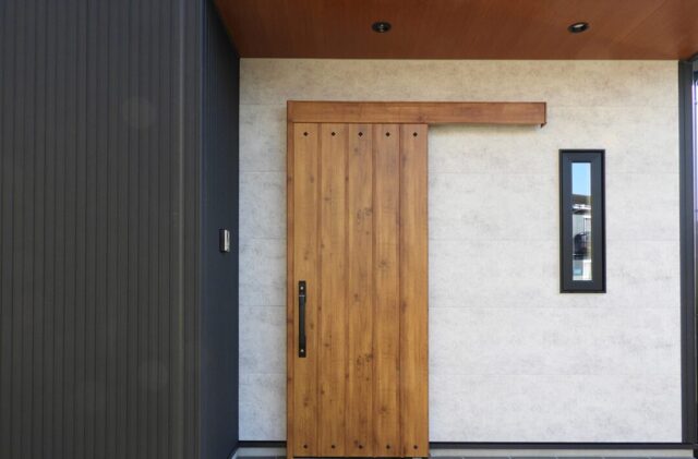 黒のガルバリウムに木のアクセントが映える豊富な収納を備えたモダンな平屋 - 向洋ハウジング - 玄関外観