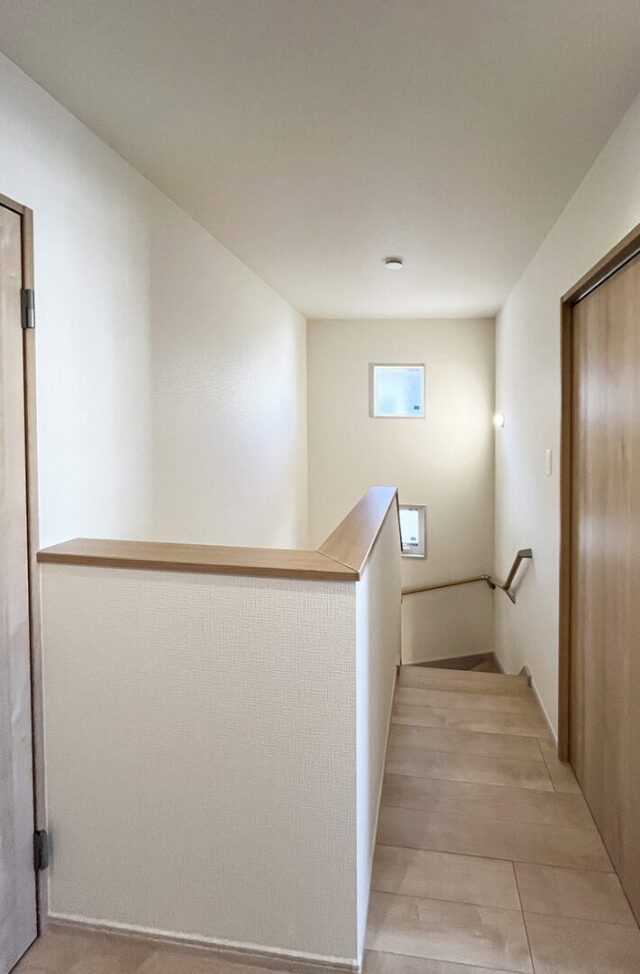 木目が心地よいナチュラルな室内とベージュのトーンで統一された外観の2階建て - 向洋ハウジング - 階段