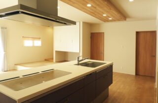 白の外壁に木目が映える豊かな緑と調和した光あふれる平屋 - 向洋ハウジング - キッチン