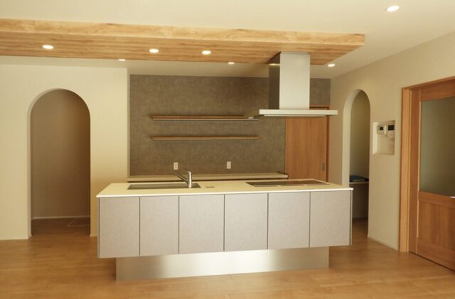 白の外壁に木目が映える豊かな緑と調和した光あふれる平屋 - 向洋ハウジング - キッチン・アーチ壁