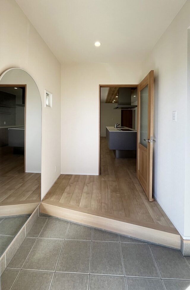 白の外壁に木目が映える豊かな緑と調和した光あふれる平屋 - 向洋ハウジング - 玄関