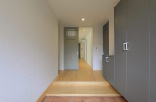 爽やかなアクセントカラーが映えるシックな佇まいの平屋 - 森建築 - 玄関