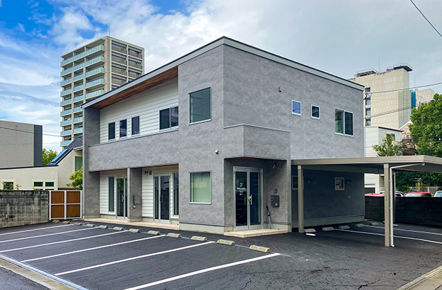 質感豊かなグレーが映えるキューブ型モダンオフィス