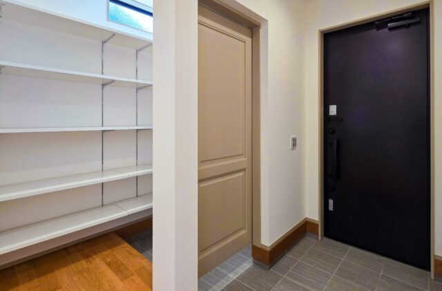 直線と勾配が映える立体的な外観と吹き抜けの開放感に包まれるシンプルデザインの家 - 日大建築 - 玄関