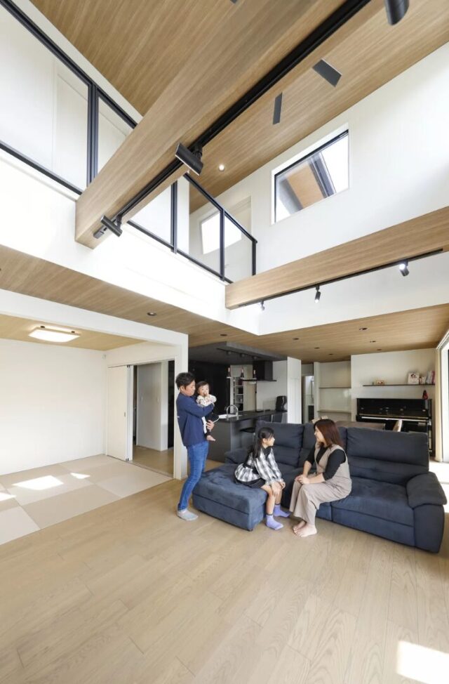 深い軒のテラスと吹き抜けが引き立つ重厚感ある住まい - 七呂建設 - 吹き抜けリビング