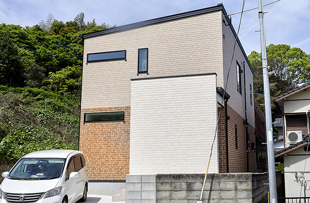 温もりあるレンガ調の外観とモダンリビングの家 - 空感考房CO.CO