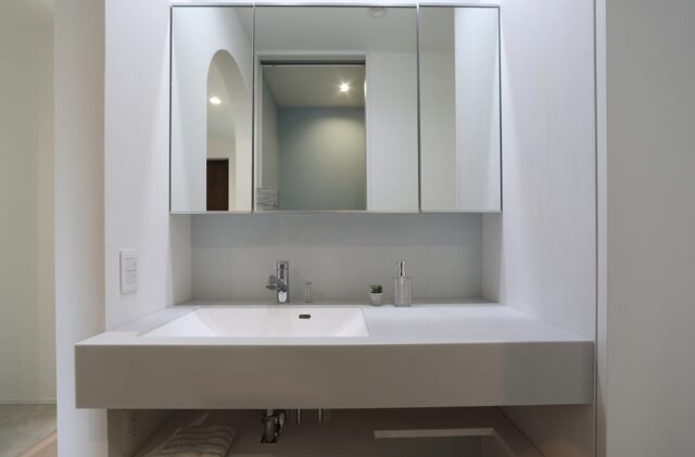 ホワイトとダークウッドのコントラストが魅せる和洋折衷の吹き抜けがある住まい - 空感考房CO.CO - 洗面スペース