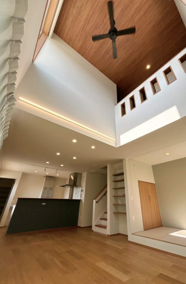 ダークトーンと木目調を組み合わせた独創的フォルムの吹き抜けがある住まい - ニッシンホーム - LDKが