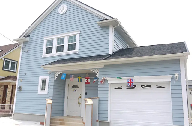 水色ラップサイディングとクラシカルな装飾が彩る2階建てカナダ住宅