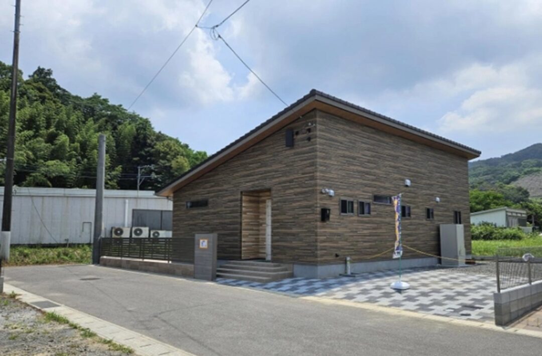 木目調の外壁が映えるモダンな片流れ屋根の明るい平屋
